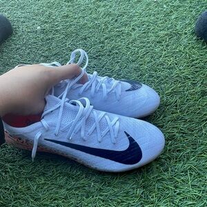 Nike White Kids Sneakers with Black Swoosh and Orange Heel Detail